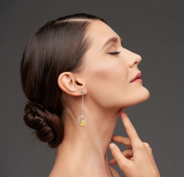 Pretty young woman touching skin of her face, isolated on grey