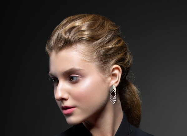 portrait of a young beautiful girl in fashionable clothes and with bright decorations on a dark background. Atelier. Close up.